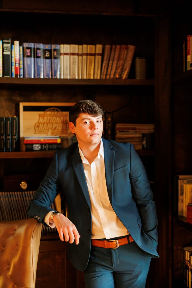 Drew Stephen standing by a bookshelf